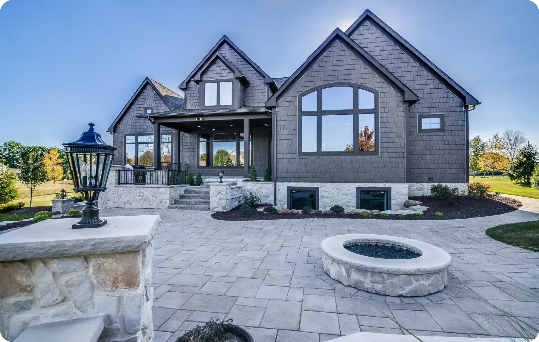 Modern house with stone patio and firepit.